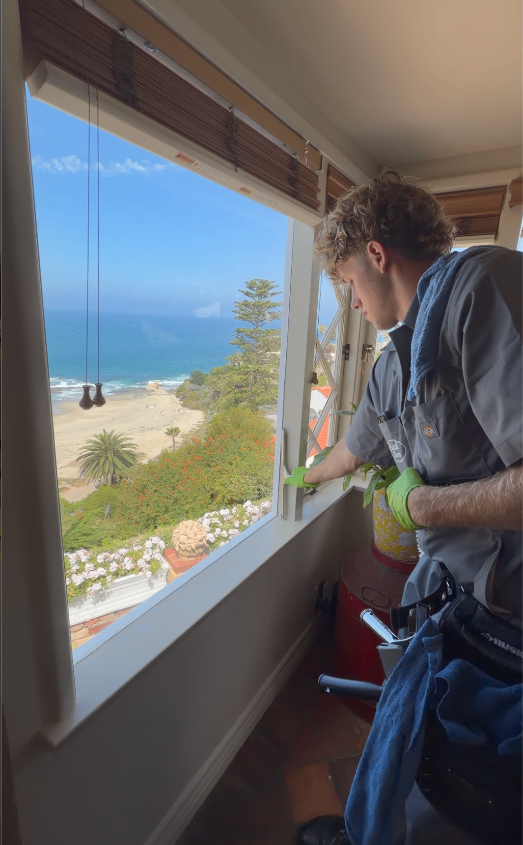 Coastal Clear technician cleaning a window with an ocean view